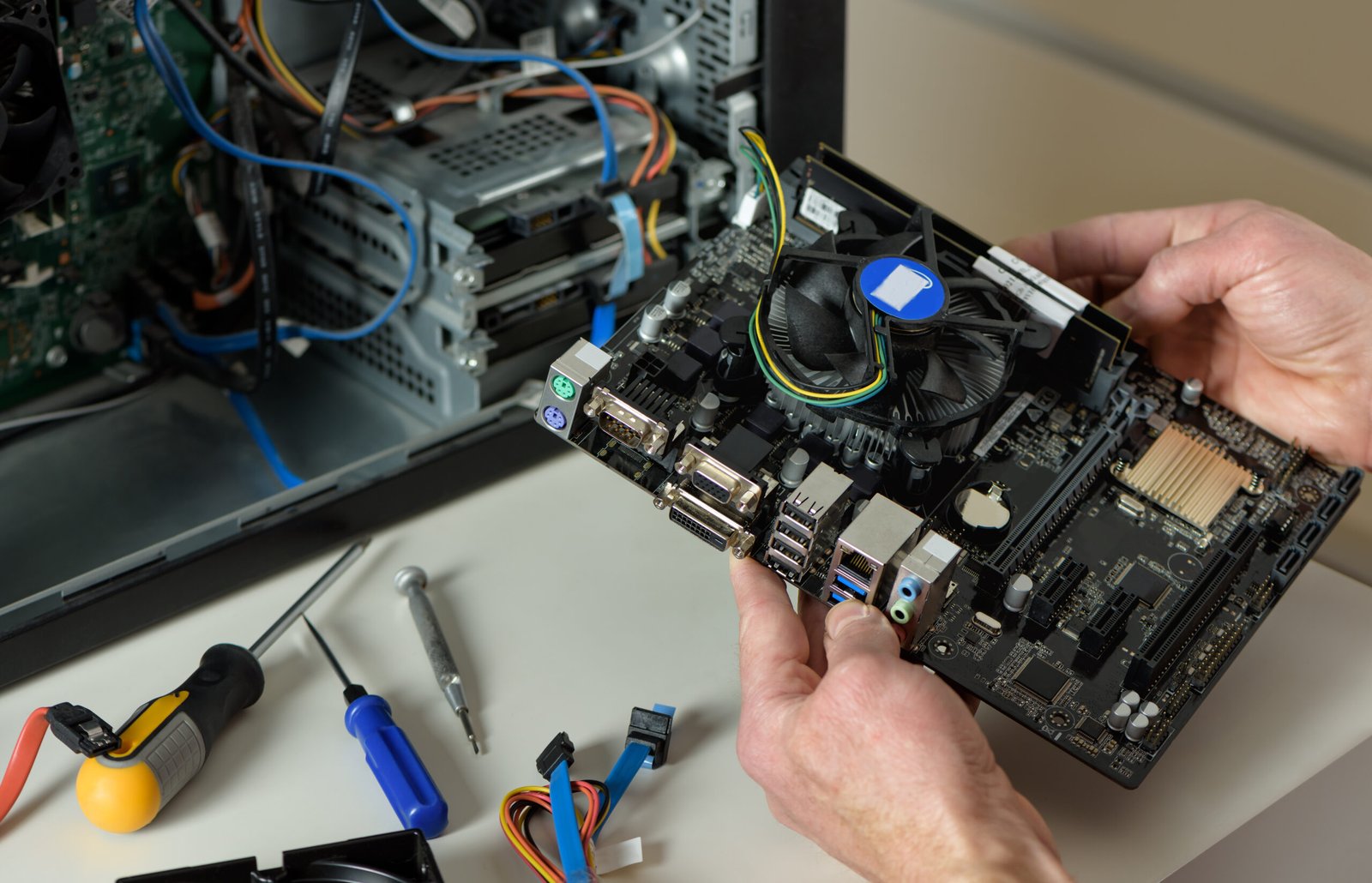 a technician is holding the motherboard in a desktop case.